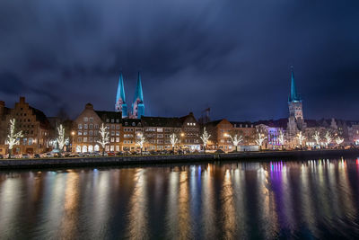 Illuminated buildings in city at waterfront