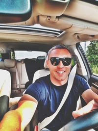 Portrait of happy friends sitting in car