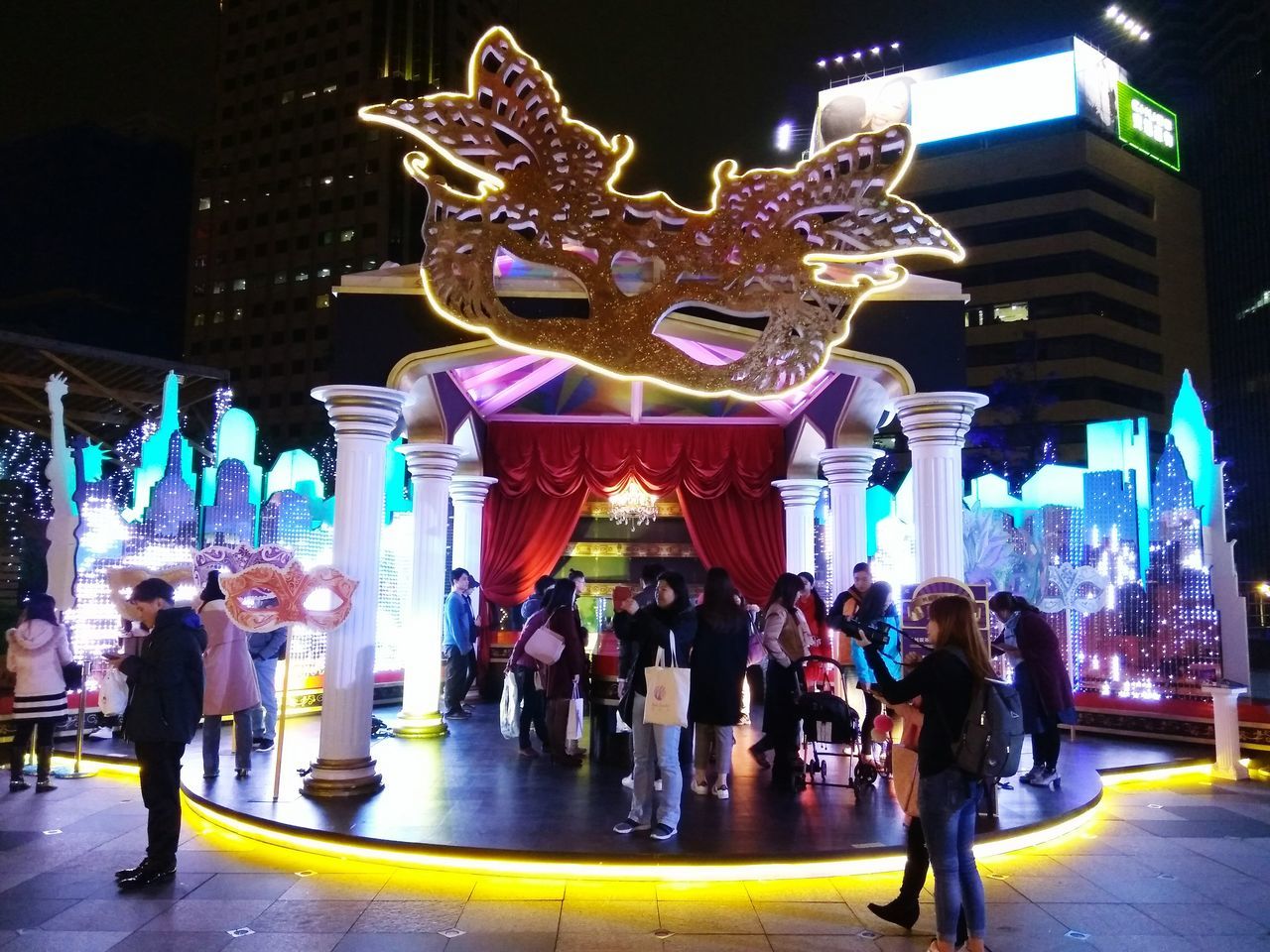 illuminated, night, large group of people, real people, architecture, celebration, built structure, lifestyles, building exterior, leisure activity, chinese dragon, sculpture, lantern, dragon, city, outdoors, crowd, people