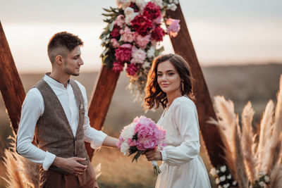 Young couple standing against white wall