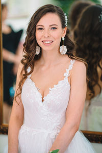 Portrait of smiling young woman standing at home