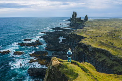 Rear view of man looking at sea against sky