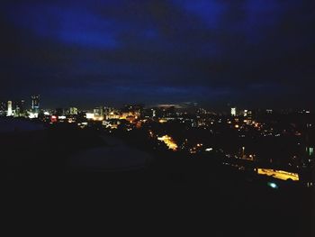 Illuminated cityscape against sky at night