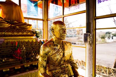 Statue against window