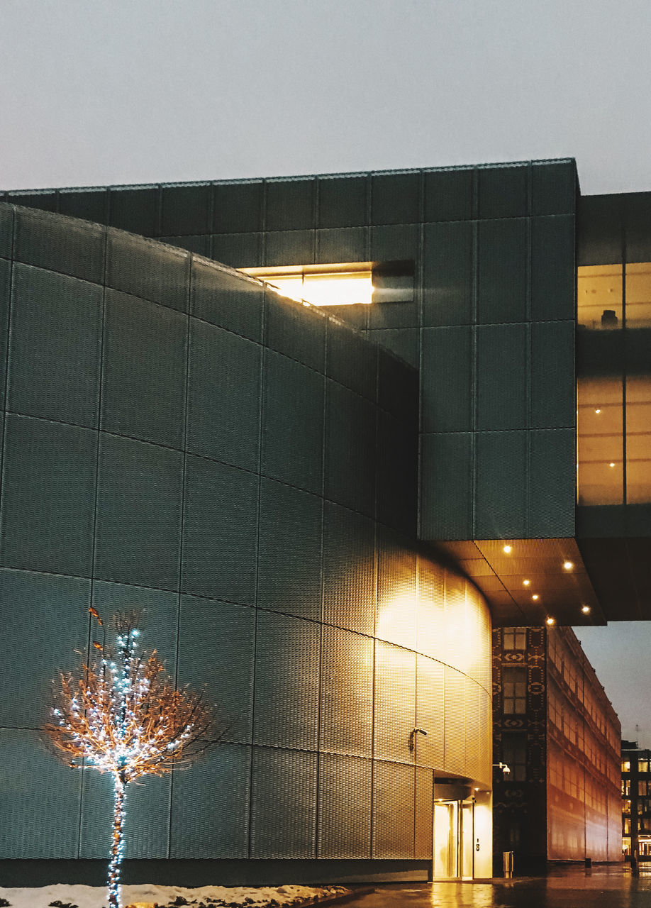 LOW ANGLE VIEW OF ILLUMINATED BUILDINGS AGAINST SKY AT NIGHT