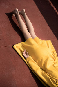 Low section of woman lying down on carpet