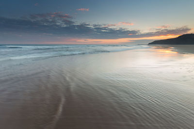 Scenic view of beach against sky during sunset