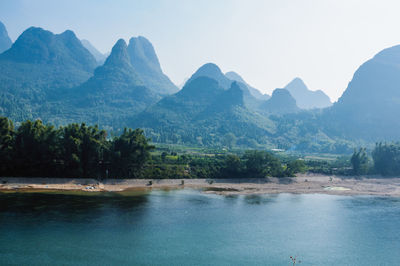 Scenic view of river and mountains against clear sky