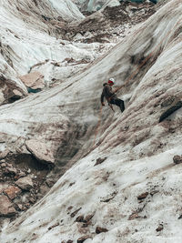 Climber rappelling into crevasses on mer de glace glacier in chamonix