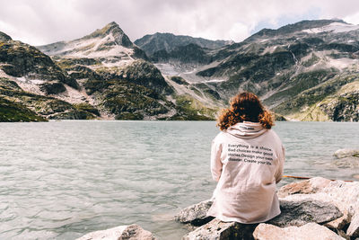 Rear view of woman looking at mountains against sky