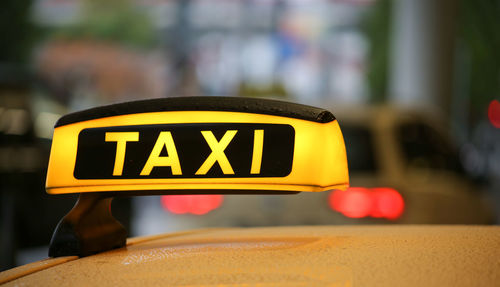 Close-up of yellow sign on car