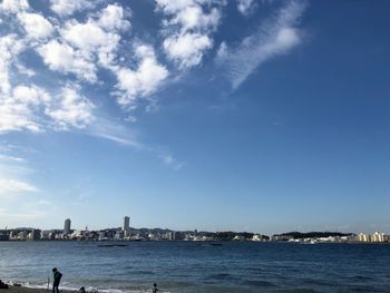 Scenic view of sea by buildings against sky