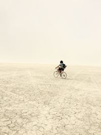 Full length of man riding bicycle at desert