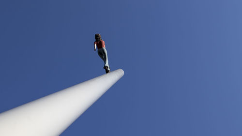 Low angle view of woman against blue sky