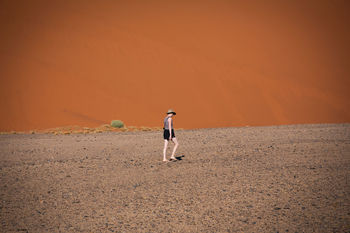 Full length of woman walking in desert on sunny day