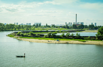 Scenic view of river against sky in city