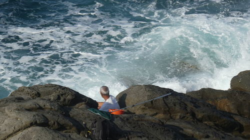 High angle view of woman sitting on rock