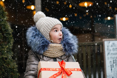 Portrait of smiling young woman with christmas tree