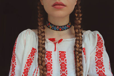 Midsection of woman standing against black background