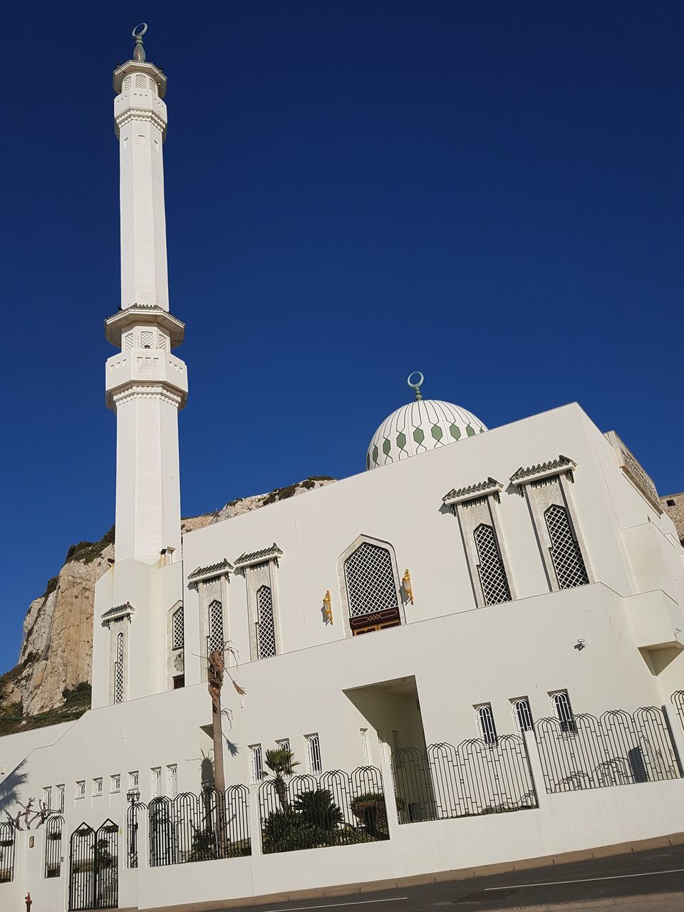 religion, architecture, low angle view, spirituality, built structure, place of worship, building exterior, clear sky, blue, outdoors, copy space, white color, day, dome, sunlight, cross, travel destinations, no people, whitewashed, sky