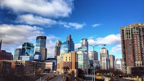 Buildings in city against cloudy sky