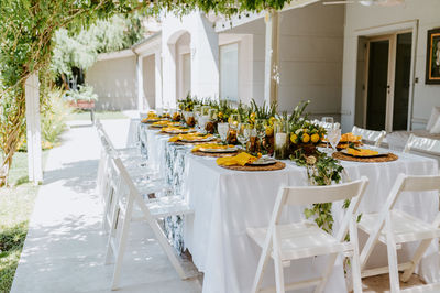 Elegant table served with compositions of lemons and empty tableware prepared for banquet in summer garden