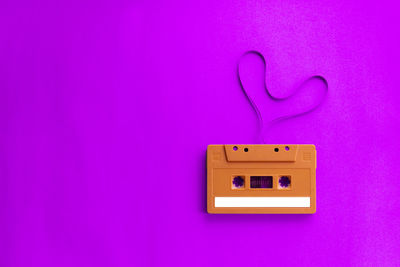 Directly above shot of audio cassette on pink background