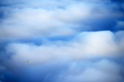 Person paragliding against clouds over el teide national park