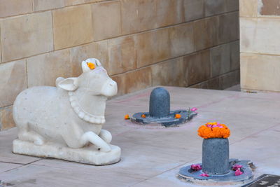 Buddha statue on table against building