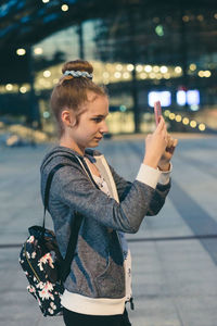 Woman standing on street in city at night