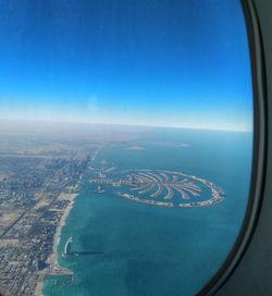 Aerial view of city against blue sky