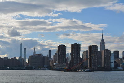 View of buildings in city against cloudy sky