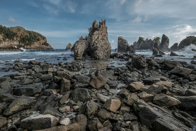 Rocks on beach against sky