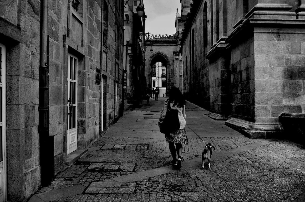 architecture, building exterior, built structure, walking, men, lifestyles, full length, the way forward, person, leisure activity, street, cobblestone, rear view, city, building, city life, alley