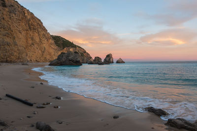 Ribeiro do cavalo paradise beach in arrabida natural park in sesimbra at sunset, portugal