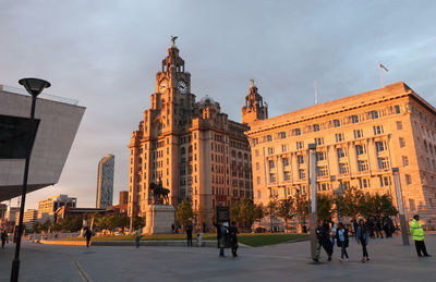 People walking on street against buildings