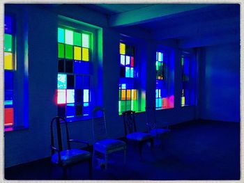 Empty chairs and tables in illuminated room