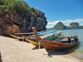 Boat moored on beach against sky