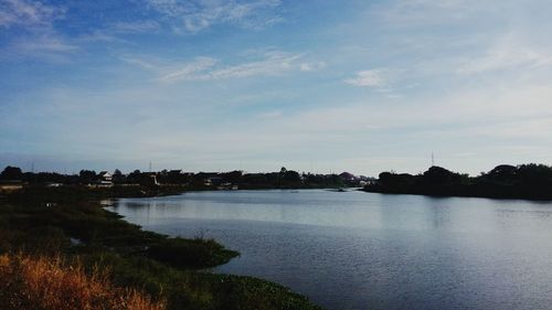 Scenic view of river against cloudy sky