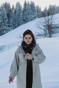 Portrait of woman standing on snow covered land