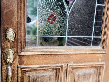 Full frame shot of red kiss on glass window in wooden door