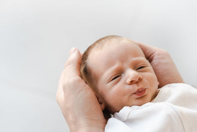 High angle view of newborn baby boy lying in father hands  at home