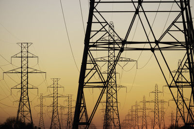 Low angle view of electricity pylon against clear sky