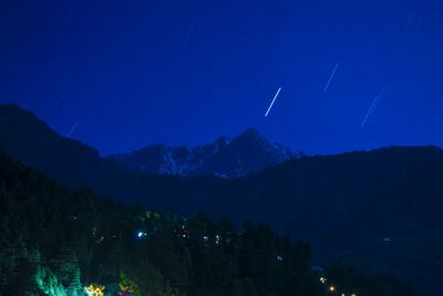 Scenic view of mountains against blue sky at night