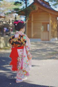 Rear view of girl in traditional clothing standing on road