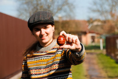 Portrait of young woman standing against trees