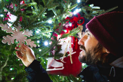 Close-up of man touching christmas decoration
