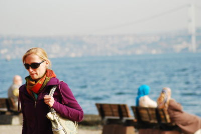 Full length of woman wearing sunglasses against sea