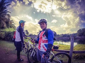 Boy riding bicycle against sky