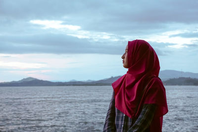 Woman looking at sea against sky